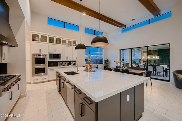 kitchen with sink, decorative light fixtures, a center island with sink, stainless steel appliances, and white cabinets