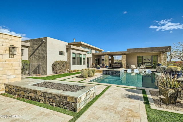 rear view of house with a patio area and an outdoor fire pit