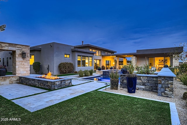 back of property featuring a patio, a yard, and an outdoor fire pit