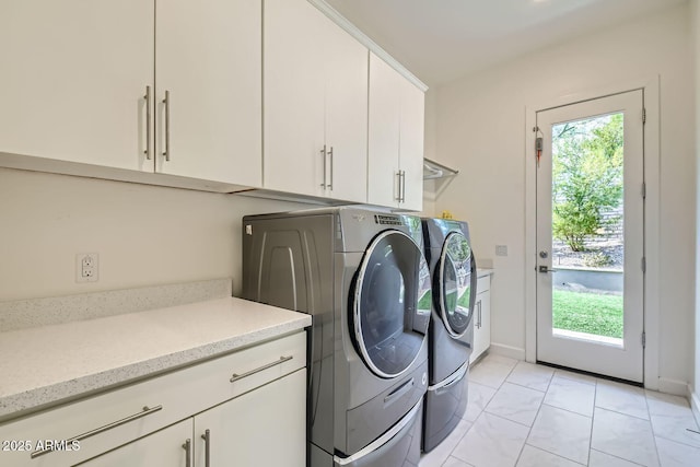 washroom featuring cabinets, a wealth of natural light, and independent washer and dryer