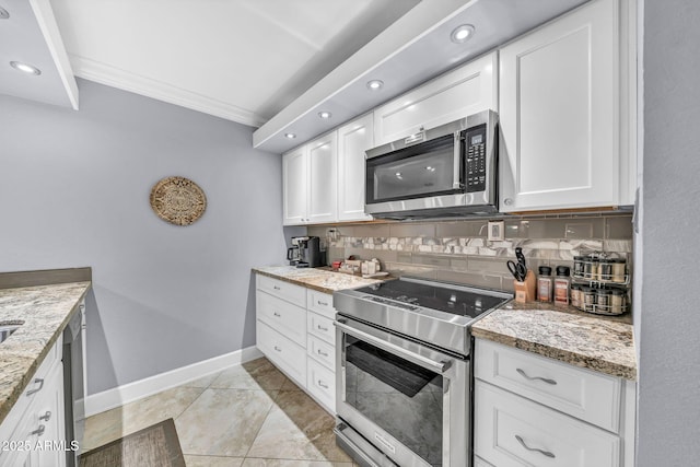 7625 E Camelback Rd Unit B138, Scottsdale, AZ 85251 - kitchen featuring appliances with stainless steel finishes, ornamental molding, baseboards, white cabinetry, and light stone countertops