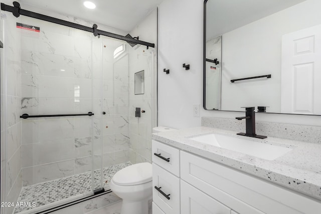 bathroom featuring vanity, toilet, and an enclosed shower