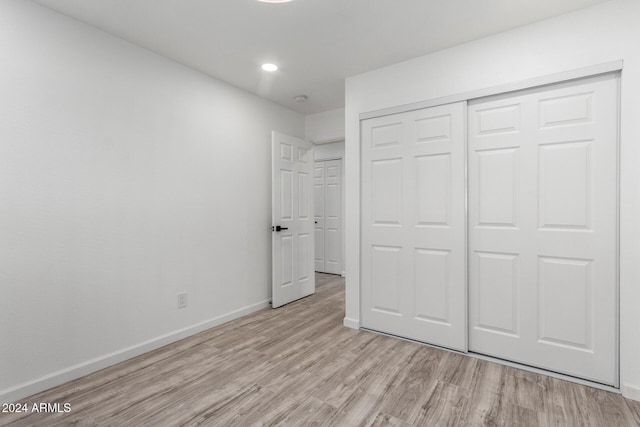 unfurnished bedroom with light hardwood / wood-style floors and a closet