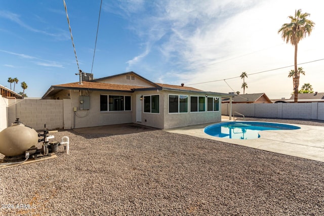 back of house featuring a fenced in pool and a patio area