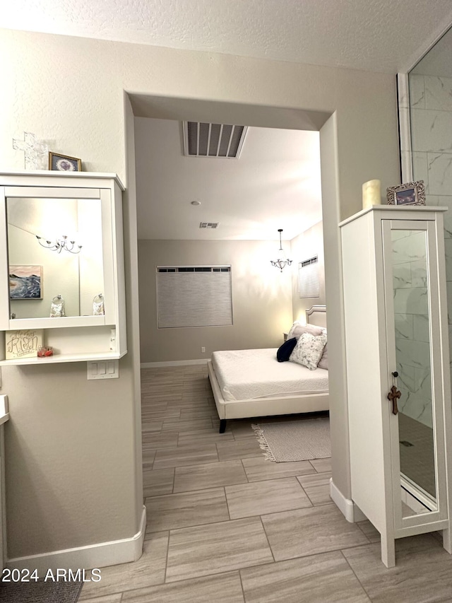 bedroom featuring a textured ceiling and a chandelier