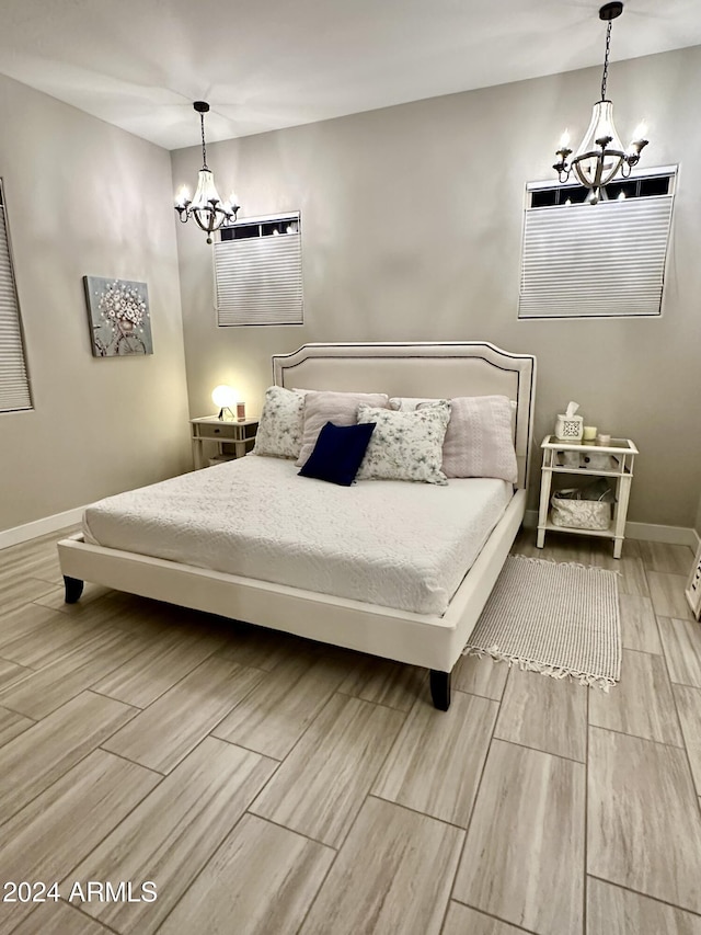 bedroom featuring an AC wall unit and a notable chandelier