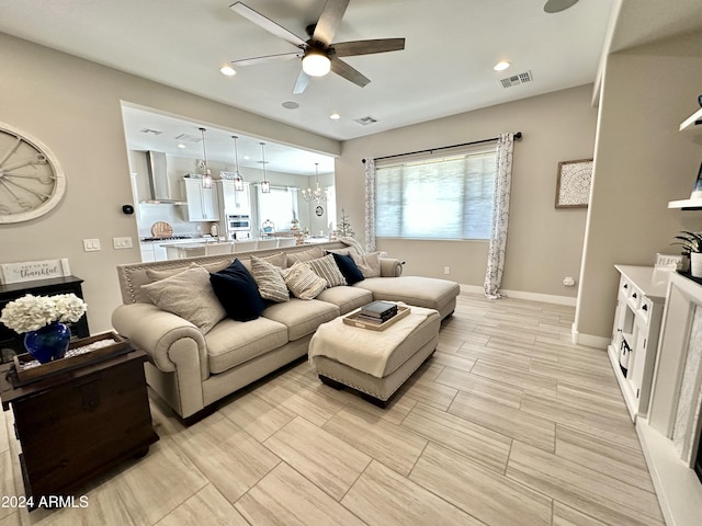 living room with ceiling fan with notable chandelier