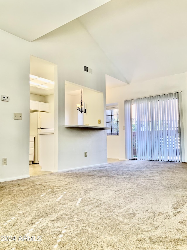 unfurnished living room featuring high vaulted ceiling and light colored carpet