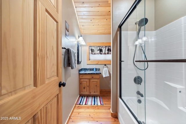 full bathroom with baseboards, wood ceiling, wood finished floors, shower / bath combination with glass door, and vanity