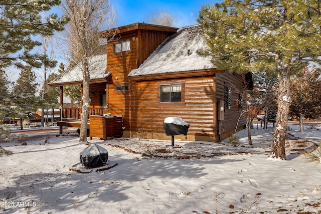 exterior space featuring faux log siding and roof with shingles