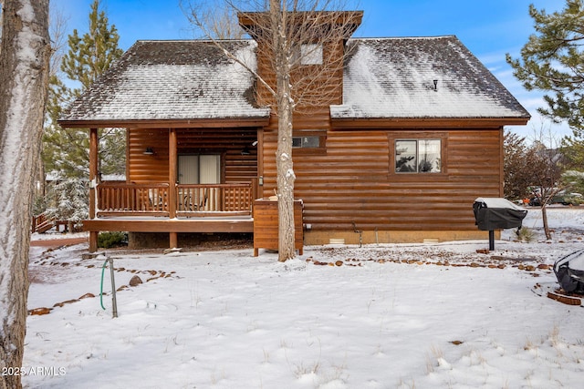 snow covered property featuring a porch, roof with shingles, and crawl space