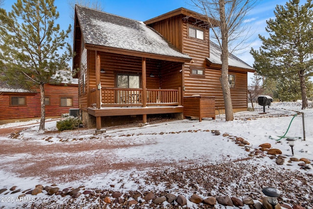 log home with central air condition unit, roof with shingles, a porch, and faux log siding