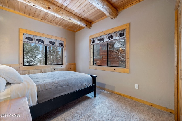 carpeted bedroom with wooden ceiling, baseboards, visible vents, and beam ceiling