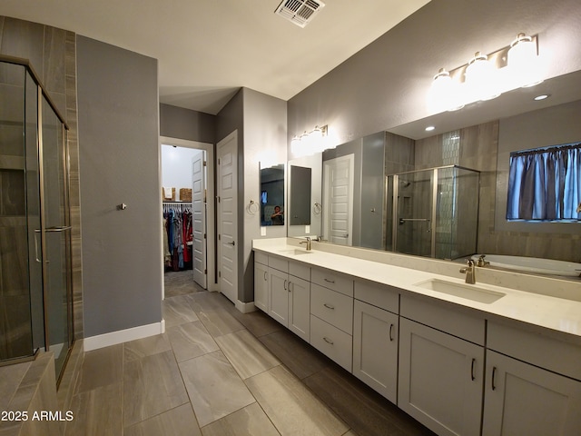 9187 W Parkside Ln, Peoria, AZ 85383 - full bath featuring a shower stall, double vanity, a walk in closet, baseboards, and a garden tub