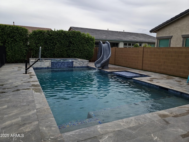 9187 W Parkside Ln, Peoria, AZ 85383 - view of swimming pool with a water slide, a fenced backyard, and an in-ground hot tub