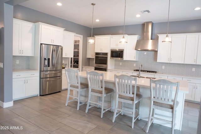 9187 W Parkside Ln, Peoria, AZ 85383 - kitchen featuring stainless steel appliances, wall chimney range hood, light countertops, tasteful backsplash, and recessed lighting