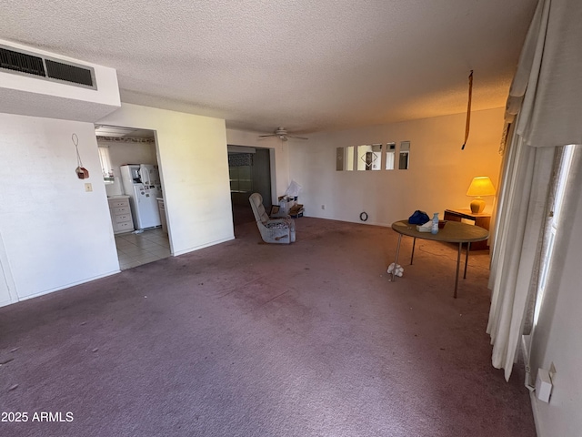 interior space featuring ceiling fan, carpet flooring, and a textured ceiling