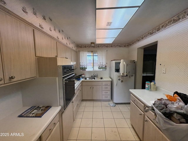 kitchen with light tile patterned floors, sink, black oven, white refrigerator with ice dispenser, and light brown cabinets