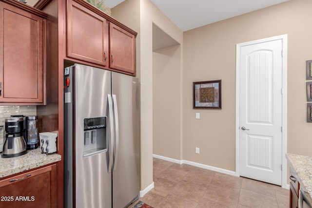20556 W Point Ridge Rd, Buckeye, AZ 85396 - kitchen with stainless steel fridge with ice dispenser, light stone counters, tasteful backsplash, baseboards, and light tile patterned floors