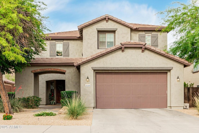view of front of home with a tiled roof, fence, driveway, and stucco siding