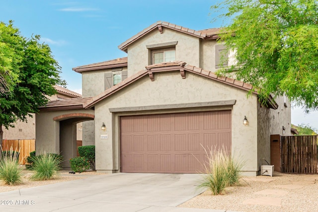 view of front of home with fence, stucco siding, driveway, and a garage