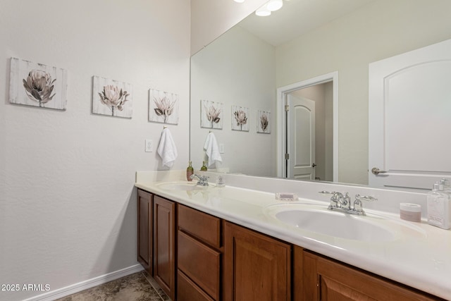 bathroom featuring double vanity, a sink, and baseboards