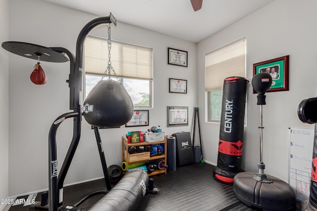workout room featuring carpet floors, baseboards, plenty of natural light, and ceiling fan
