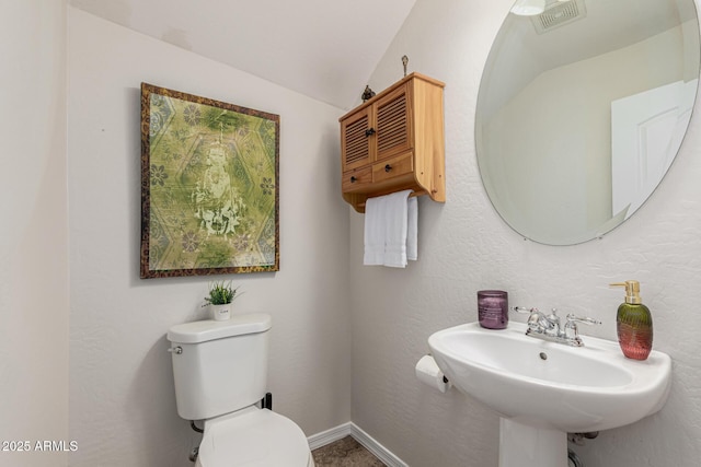 bathroom with toilet, visible vents, and a sink