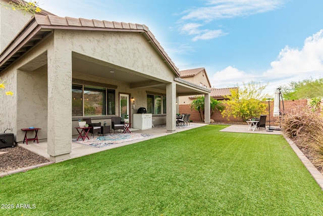 rear view of house featuring a yard, a patio, a fenced backyard, and stucco siding