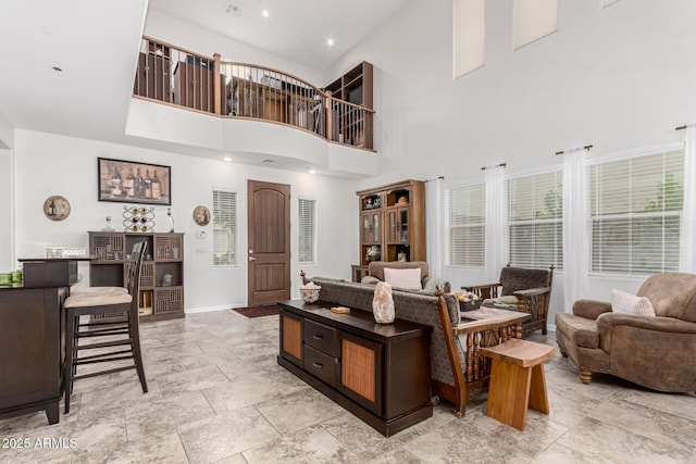 living room with baseboards and a towering ceiling