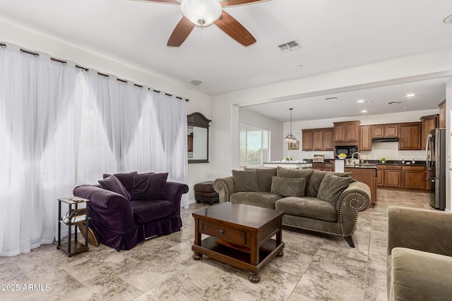living room with a ceiling fan and visible vents