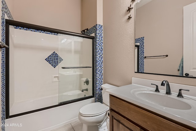 bathroom featuring tile patterned flooring, toilet, a textured wall, shower / bath combination with glass door, and vanity