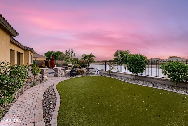 view of yard with a patio area, fence, and a water view