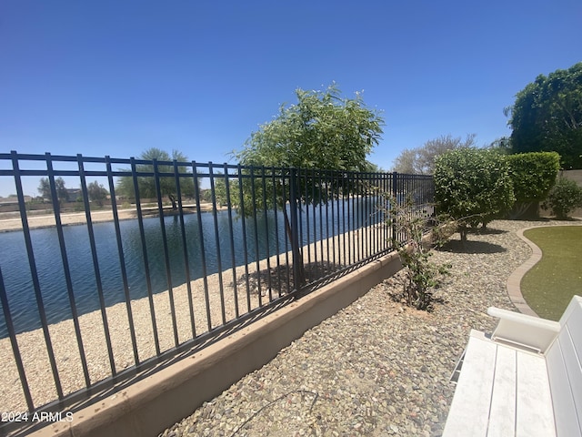 view of gate featuring a water view and fence