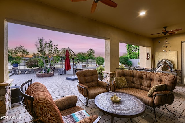 patio terrace at dusk featuring outdoor lounge area and fence