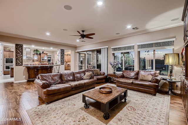 living room with visible vents, crown molding, ceiling fan, recessed lighting, and wood finished floors