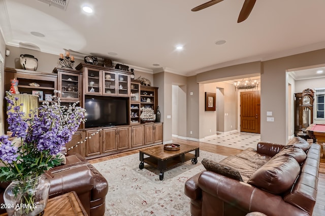 living area with light wood-style flooring, a ceiling fan, recessed lighting, crown molding, and baseboards