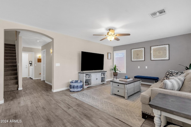 living room with light hardwood / wood-style flooring and ceiling fan