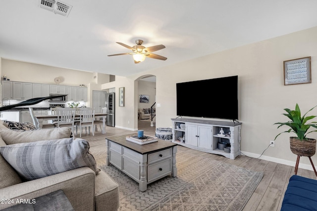 living room with light wood-type flooring and ceiling fan