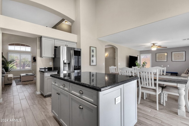 kitchen featuring plenty of natural light, a kitchen island, light wood-type flooring, and stainless steel fridge with ice dispenser