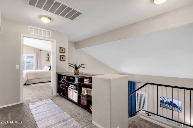 hall with carpet flooring and vaulted ceiling