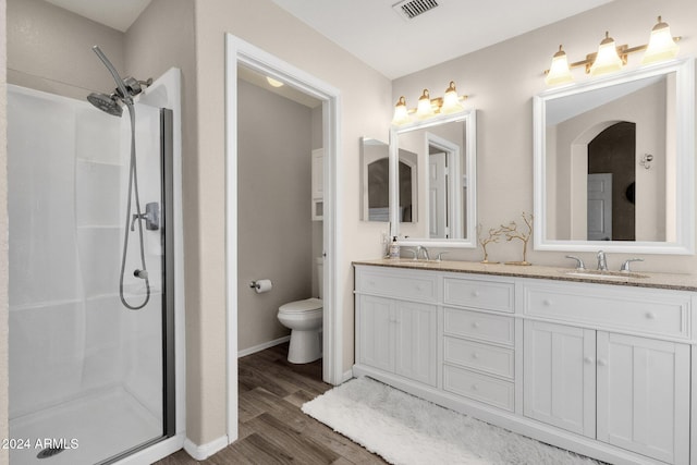 bathroom featuring toilet, vanity, wood-type flooring, and walk in shower