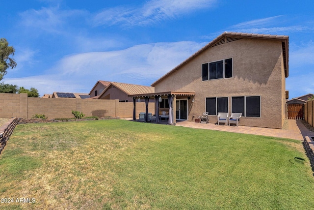 back of property with a yard and a patio area