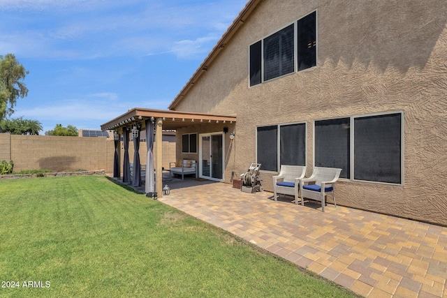 back of property with a yard and a patio