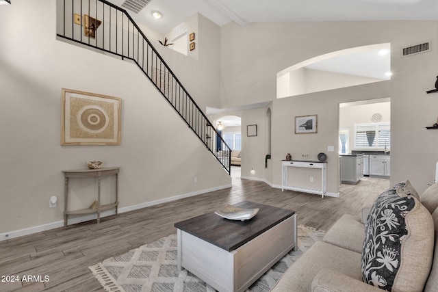 living room featuring light hardwood / wood-style floors and high vaulted ceiling