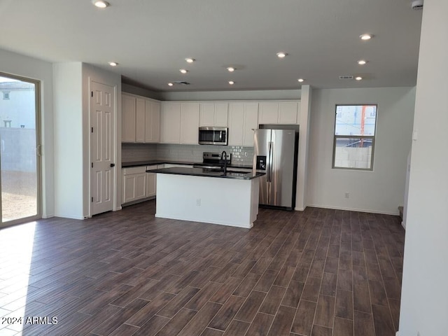 kitchen featuring white cabinetry, dark wood-type flooring, a kitchen island, and appliances with stainless steel finishes