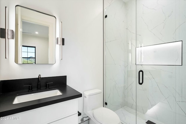 full bath with toilet, a marble finish shower, and vanity