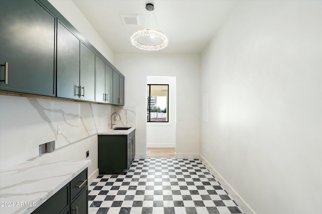 laundry area with visible vents, light floors, a sink, and cabinet space