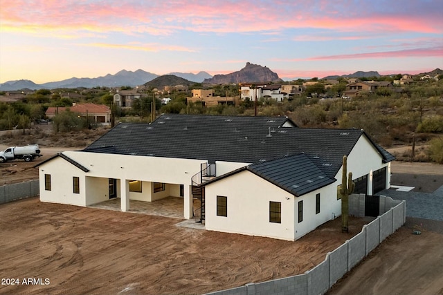 rear view of property featuring stucco siding, fence, and a mountain view