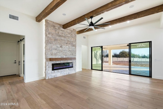 unfurnished living room with a fireplace, visible vents, light wood-style floors, a ceiling fan, and baseboards